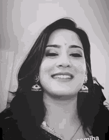 a black and white photo of a smiling woman with the name pomisha on the bottom right