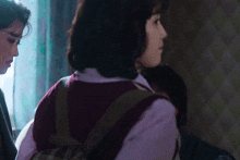 a woman in a plaid vest is standing next to a man