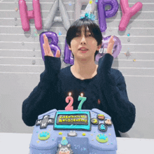 a man stands in front of a cake that says 27th