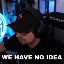a man wearing headphones and a hat is sitting in front of a computer and says `` we have no idea '' .