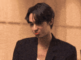 a man wearing a black jacket and a gold chain