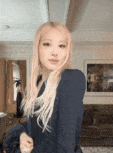 a woman with long blonde hair is standing in a room