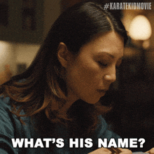 a woman sitting at a table with the words what 's his name on her face
