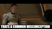 a man in a space suit is talking to another man and the caption says thats a common misconception .