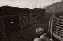 a black and white photo of a person holding a gun in a trench