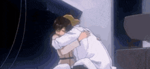 two people are hugging each other in a room .