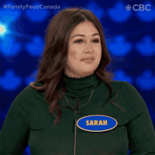 a woman wearing a name tag that says sarah is laughing