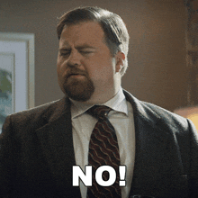 a man in a suit and tie says no in white letters