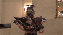 a man in a costume with the letter r on his chest is holding a gun