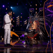 a man in a white suit is standing next to a leopard costume