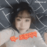 a girl laying on a bed with chinese writing on her face