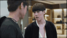 two young men are standing next to each other in a room .