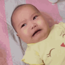 a baby is wearing a yellow shirt with a deer face on it
