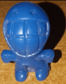 a blue toy with a helmet on it is on a table