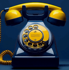 a blue and yellow telephone with a yellow cord against a dark blue background