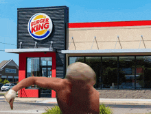 a shirtless man stands in front of a burger king