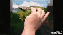 a hand is holding a spatula and painting on a canvas with the words made in animotica below it