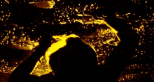 a silhouette of a person standing in the dark with a yellow light behind them