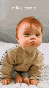 a baby is crawling on a white blanket with the name miles scott on the bottom