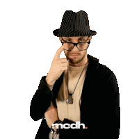 a man wearing glasses and a hat with the word mcdh on the bottom right