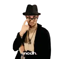 a man wearing glasses and a hat with the word mcdh on the bottom right