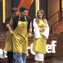 a couple of people wearing yellow aprons with a m on them