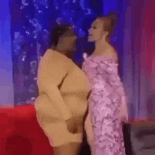 a couple of women are standing next to each other on a stage and kissing .