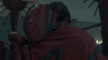 a man with a red face is pointing a gun