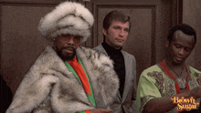 a man in a fur coat stands next to two other men with the words brown sugar on the bottom right