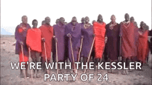 a group of people are standing next to each other in a line holding sticks and shields .