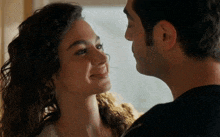 a man and woman are looking at each other and smiling