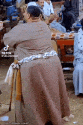 a man with a cane is standing in front of a group of people with tiktok written on the bottom right corner