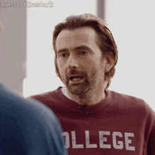 a man with a beard wearing a college sweatshirt