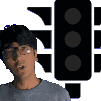 a man wearing glasses is standing in front of a black traffic light