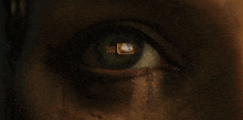 a close up of a person 's eye with a reflection of a house