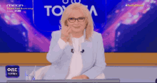 a woman is sitting in front of a sign that says mega