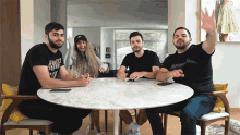 a group of people are sitting around a table and one of them has a shirt that says rocket fuel