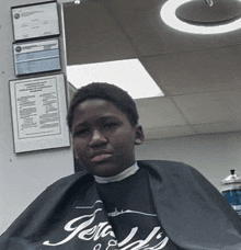 a boy is getting his hair cut at a barber shop