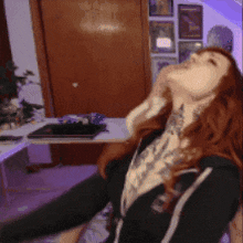 a woman with red hair and a tattoo on her neck is standing in a room