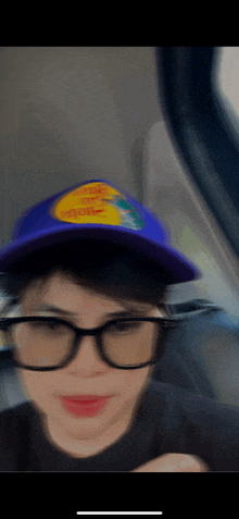 a blurry picture of a person wearing glasses and a hat that says chupa chups on it