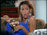 a woman in a blue top is eating a dessert