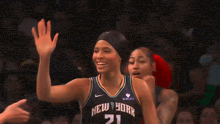 a female basketball player wearing a new york 21 jersey smiles