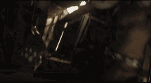 a baby yoda is laying on the floor next to a man in a dark room .