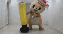 a stuffed animal mascot is standing next to a punching bag in a room .