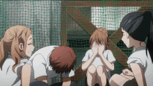 a group of people covering their faces with their hands in front of a net