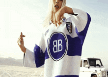a woman wearing a blue and white sweater with the letters 8b on it