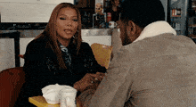a man and a woman are sitting at a table and talking