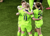 a group of female soccer players are hugging each other and one of them has the number 11 on her jersey