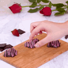 a person is dipping a chocolate covered strawberry in pink icing