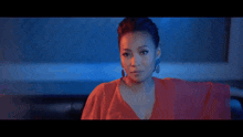 a woman in a red dress is looking at the camera with a blue background